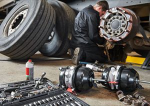 A man working on the wheels of an airplane.